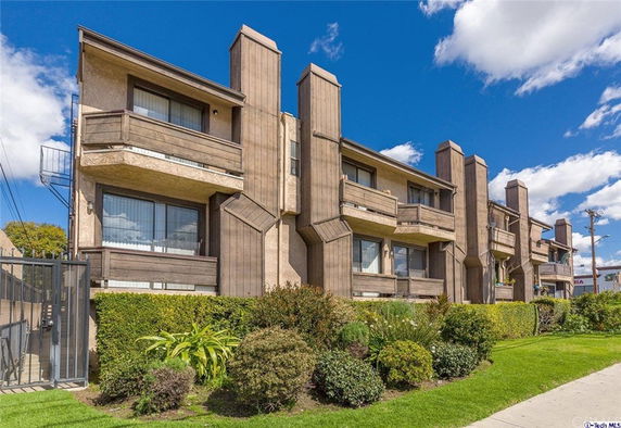 Front view of a residential building with multiple balconies and a geometric facade.