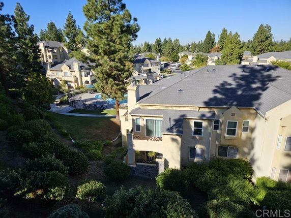 View of a residential area with multiple two-story houses and surrounding greenery.