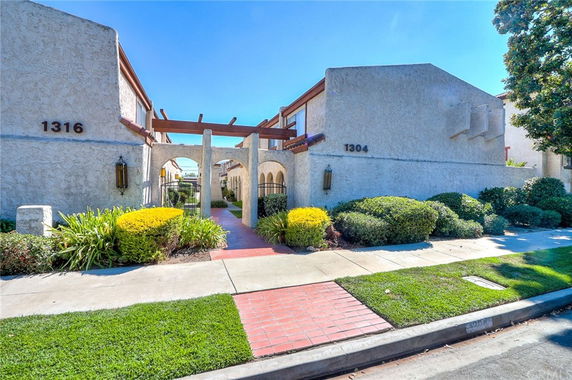 Front view of a building complex with stucco exterior and decorative archway.