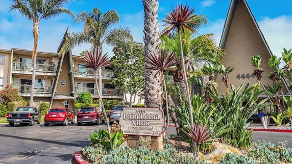 Front view of a condominium complex with multiple floors and distinct roof design.