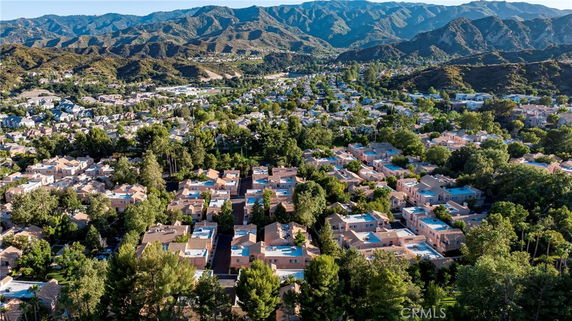 Panoramic view of a suburban neighborhood with houses and mountainous landscape in the background.