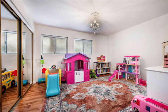 Interior of a playroom with toys and a small playhouse.