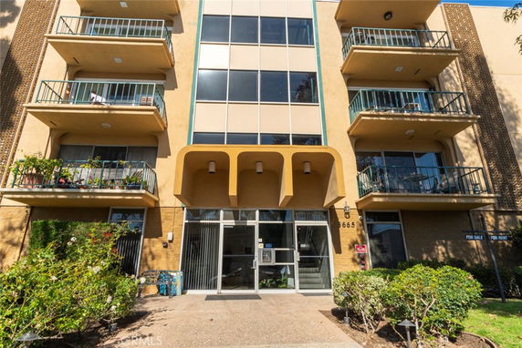 Front view of a multi-story residential building with balconies.