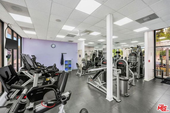 Interior view of a gym with exercise equipment and mirrored walls.