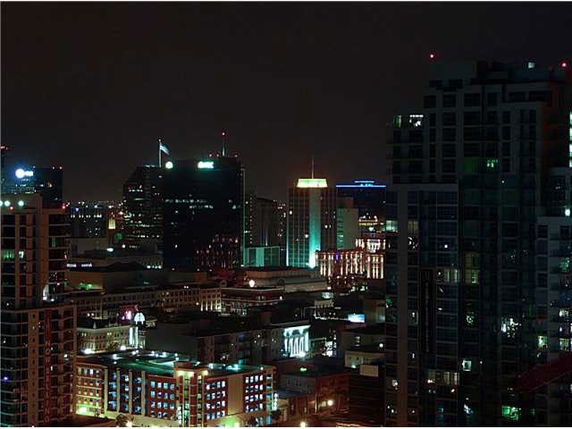 Night view of a city skyline with illuminated buildings.
