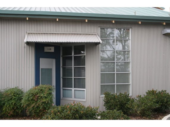 Front view of a building with large windows and metal siding.