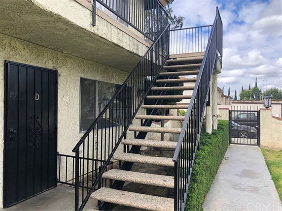 Exterior view of a building with staircase leading to the upper level entrance.