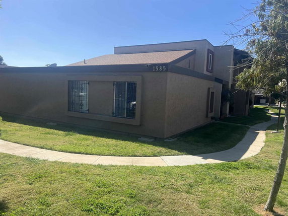 Front view of a single-story house with barred windows and a sloped roof.