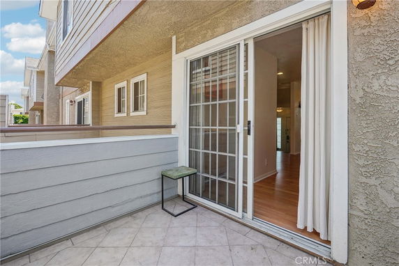 View of a balcony area with sliding glass doors leading inside a house.