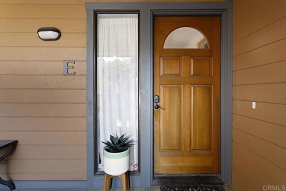 Front view of a house with a wooden door and side window.