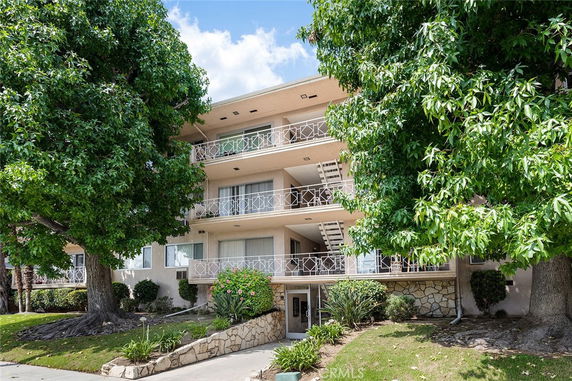 Front view of a three-story apartment building with balconies.