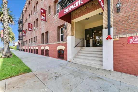 Front view of a multi-story brick building with stairway entrance.