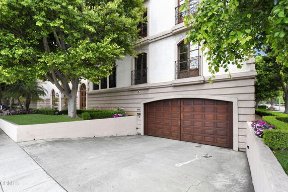 Front view of a multi-story building with a wooden garage door.