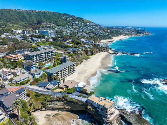 Panoramic view of coastal cityscape with beachfront buildings and ocean.
