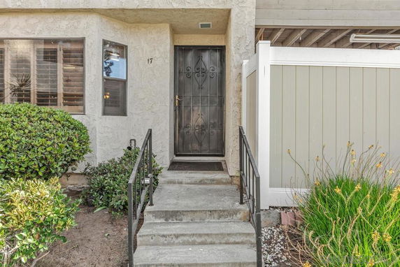 Front view of a house entrance with a metal door and small staircase.