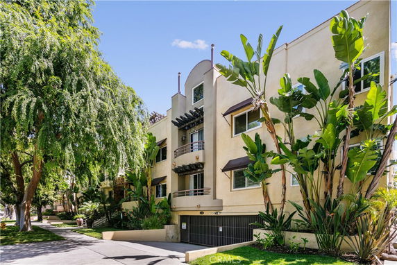 Front view of a multi-story apartment building with balconies and large windows.