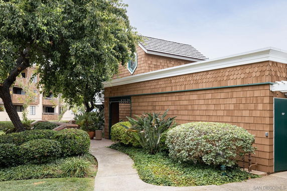 Front view of a house with shingle siding and a path leading to the entrance.