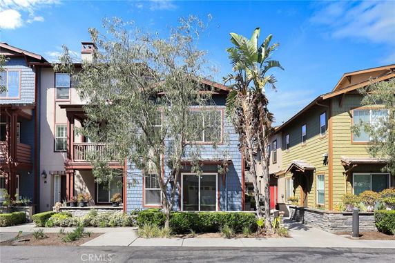 Front view of a two-story townhouse with balconies and a blue exterior.