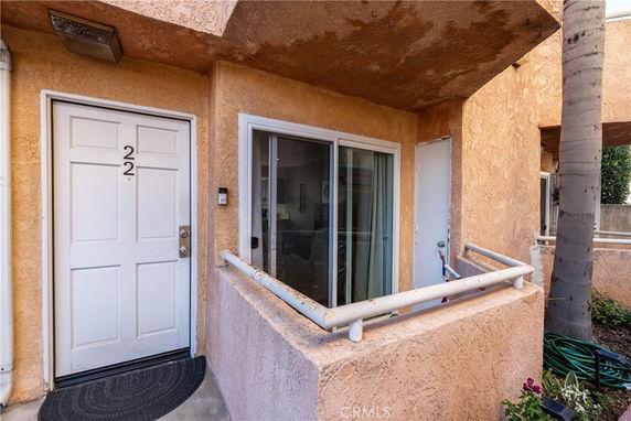 Front view of an apartment entrance with a small patio area.