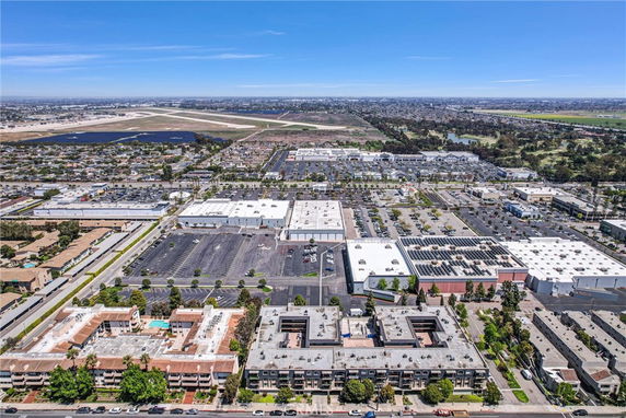 Aerial panoramic view of urban area with multiple buildings and parking lots.