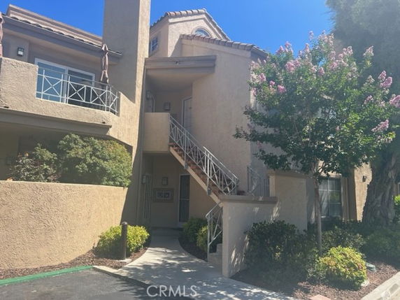 Front view of a two-story building with a staircase and a small balcony.