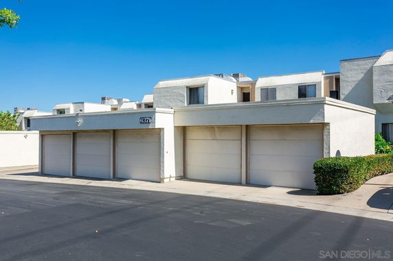 Front view of a modern multi-story building with garages.
