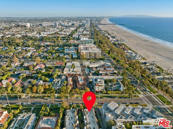 Aerial view of a coastal cityscape with a beach and numerous buildings.