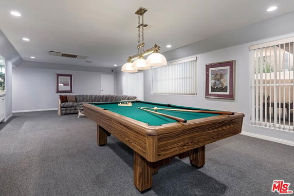 Room with a pool table and seating area.