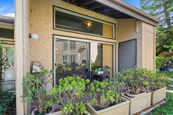 Front view of a house with large windows and patio seating area.