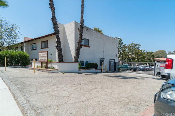 Front view of a two-story building with a sign and parking area.
