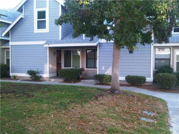 Front view of a house with gray siding and a small porch.
