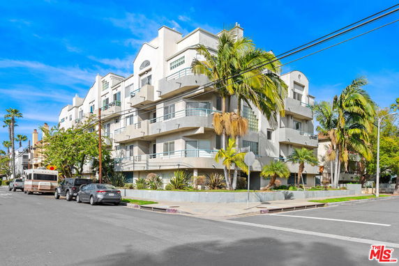 Front view of a multi-story apartment building with balconies.