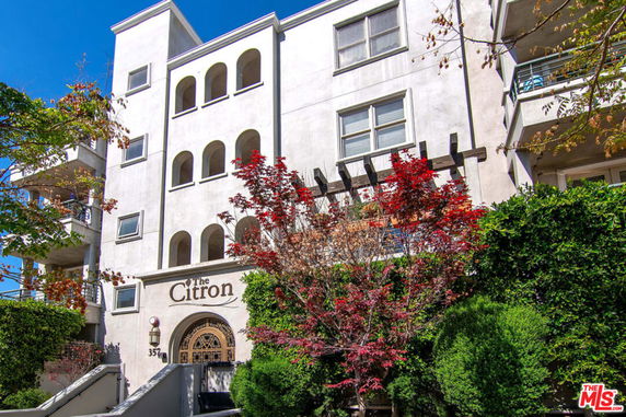Front view of a multi-story building with a decorative arch entrance.