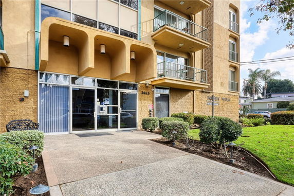 Front view of a multi-story building with balconies and entrance.