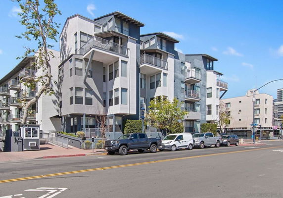 Front view of a modern multi-story apartment building with balconies and large windows.