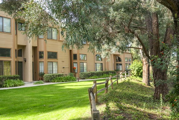 Front view of a multi-story building with large windows and beige exterior.