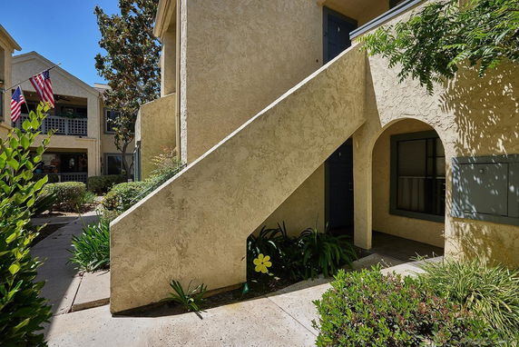 Front view of a two-story apartment building with external staircase.