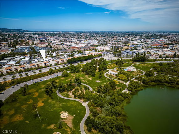 Aerial view showing a panoramic landscape of a city with a park, roads, and numerous buildings.