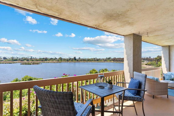 Balcony view over a scenic lake and distant treeline.