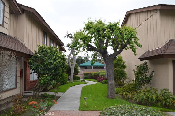 Front view of residential buildings with walkways and gardens.