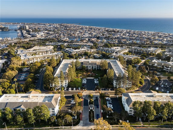 Aerial view of a coastal cityscape with multiple residential buildings and a view of the ocean.
