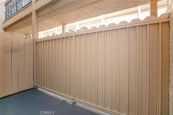 Outdoor enclosed area with wooden fencing and overhead structure.
