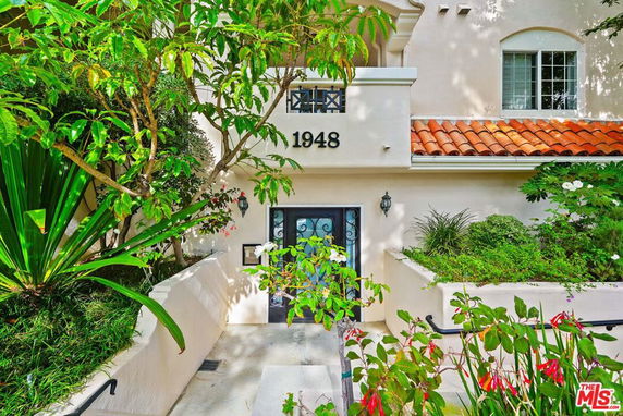 Front view of a house with a decorative entrance, number 1948 displayed, and a tiled roof.