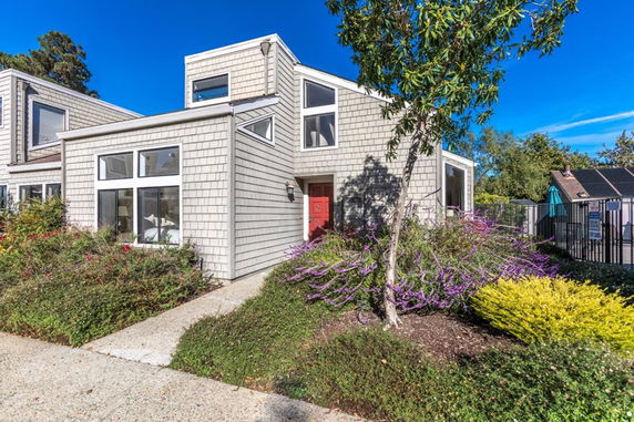 Front view of a contemporary house with large windows and a red door.