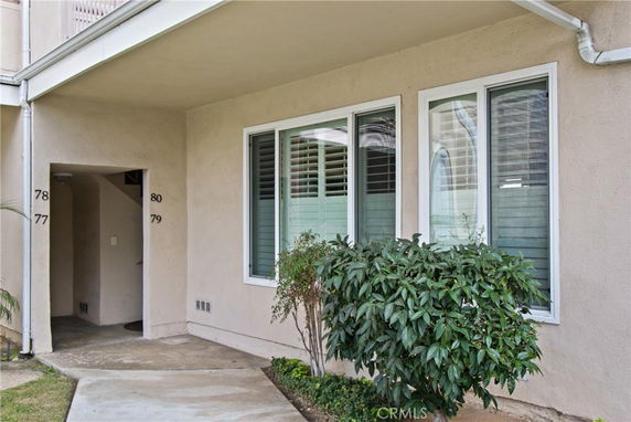 Front view of a building entrance with numbered units and windows.