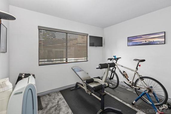 Room with exercise equipment, a bicycle, and wall decor.