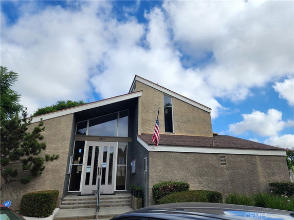 Front view of a building with a steep roof and large front windows.