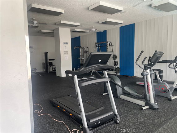 Indoor gym area with exercise equipment including treadmills and weight machines.