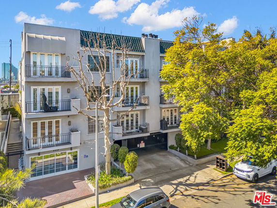 Front view of a four-story residential building with multiple balconies.