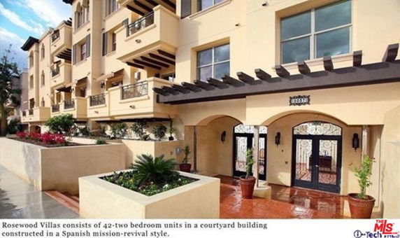 Front view of a Spanish mission-revival style apartment building with multiple balconies.